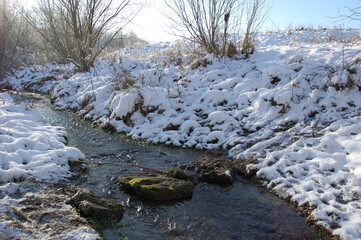 Obraz na płótnie Canvas Forest river in winter snow .Detail on river running through snowy landscape