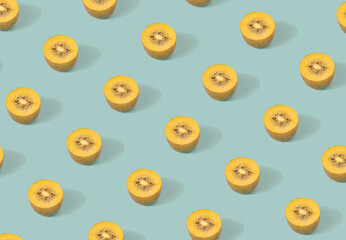 Gold kiwi halwes pattern on a pastel blue background. Organic plants minimal flat lay