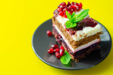 Colorful multi-layered cream chocolate cake with cherry jam and pomegranate