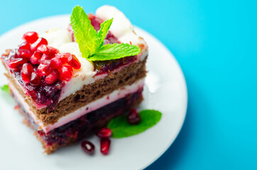 Colorful multi-layered cream chocolate cake with cherry jam and pomegranate