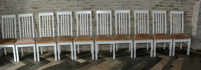 Row of chairs against wall .Close-up of white wedding chairs