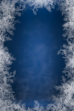 Frosty frame. Decorative ice crystals frame on dark blue background