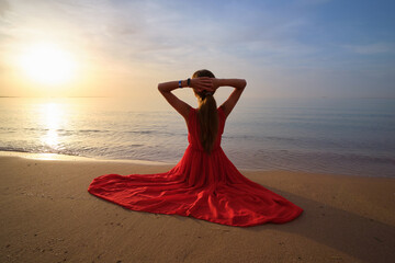 Fototapeta na wymiar Lonely young woman sitting on ocean sandy beach by seaside enjoying warm tropical evening