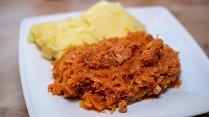 bigos with potatoes on a white plate