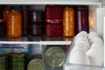 White raw chicken eggs in a tray of the refrigerator