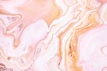 Abstract background in pink and orange with marble texture from closeup of acrylic pour art
