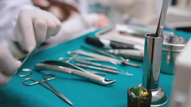 Close up hands of dentist check and manage tools and equipment of dental procedure for patient in clinic.