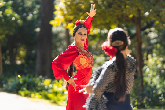 Two hispanic women dancing flamenco in a park