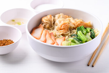 Noodles soup with wonton dumpling and grilled red pork in bowl on white background, Asian food