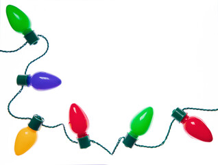 An original holiday photograph of a string of festive colorful Christmas lights on a bright white...