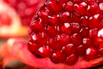 Juicy pomegranate and its half Beautiful composition with juicy pomegranates, on old wooden table
