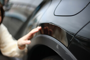 	車の傷を確認する女性