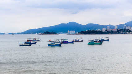 Fototapeta na wymiar Traditional Vietnamese fishing boats parked and floating in the water after a long day of work in Nha Trang Bay, Vietnam