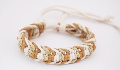 An isolated ethnic bracelet on white background. The bracelet is made off the various rope