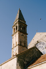 Fototapeta na wymiar Bell tower with the clock of the Church of St. Nicholas on the background of the sky. Montenegro