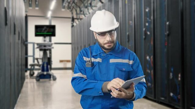 Young engineer using tablet to inspection programable database service workstation server room

