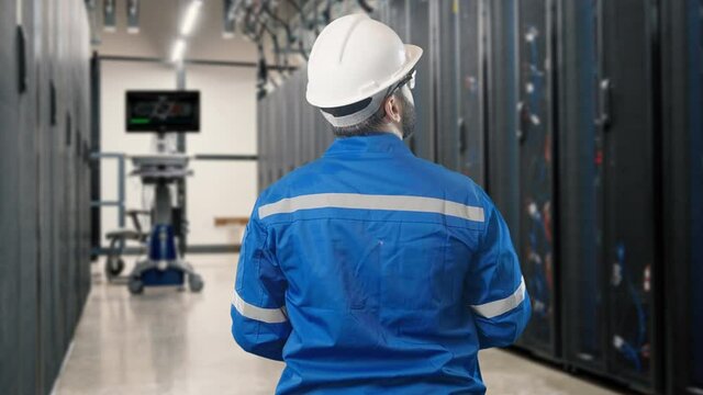 Young engineer using tablet to inspection programable database service workstation server room


