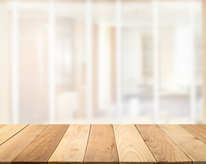 Empty wooden table top with blur image of a door in the hotel interior nature guest room in the daytime perspective background, copy space for your text ready for product promotion display montage