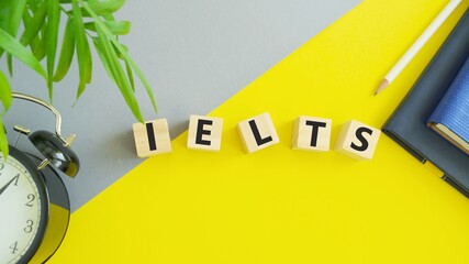 On wooden blocks under text: IELTS. IELTS words from wooden blocks with letters, International English Language Testing System IELTS exam concept