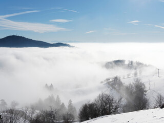 Zeller Bergland im Südschwarzwald. Panoramablick ins Wiesental zwischen Zell im Wiesental, Basel und Feldberg, Hügel und Berge bei Schnee und Nebel