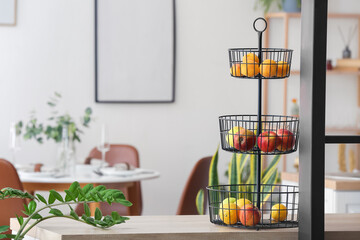 Stand with healthy fruits on table in kitchen