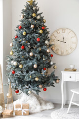 Stylish interior with Christmas tree and clock on light wall
