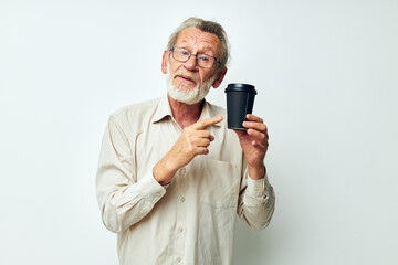 Fototapeta premium Photo of retired old man with a gray beard in a shirt and glasses light background