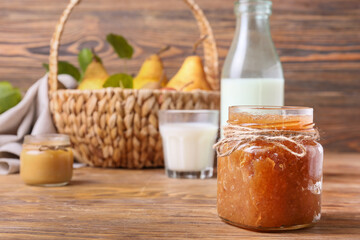 Glass jar of tasty pear jam on wooden table