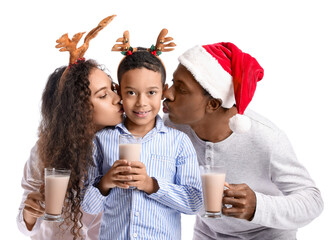 Happy African-American family in pajamas, with Christmas decor and tasty hot chocolate on white background