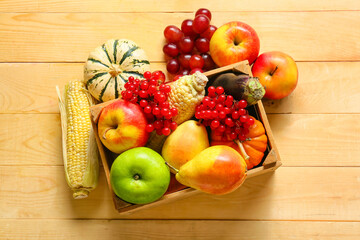 Box with different healthy food on wooden background. Harvest festival