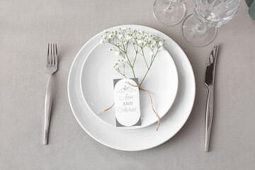 Beautiful table setting with wedding invitation, top view