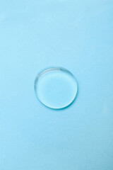 Drop of liquid transparent gel on blue background