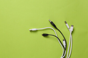 Different usb cables on green background. Top view