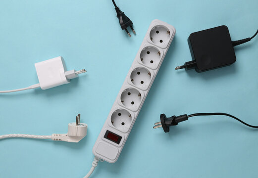 Electrical Extension cord with different plugs and adapters on blue background. Top view