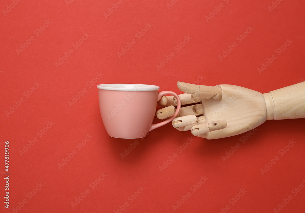 Wall mural wooden hand holding empty tea cup on red background