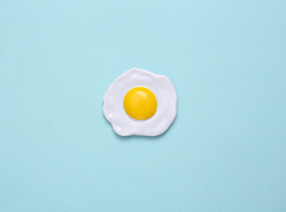 Plastic scrambled eggs on a blue pastel background. Top view. Minimal food concept