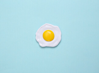 Plastic scrambled eggs on a blue pastel background. Top view. Minimal food concept