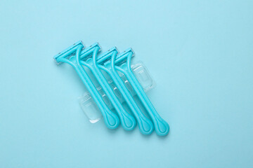 Set of disposable razors for depilation on blue background. Top view