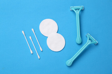 Hygiene, body care concept. Shaver depilator, cotton pad and sticks on a blue background. Top view