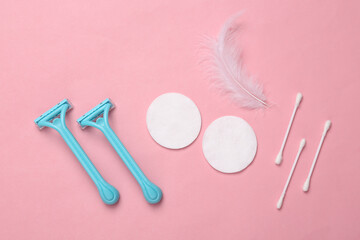 Hygiene, body care concept. Shaver depilator, feather, cotton pads and sticks on pink background. Top view