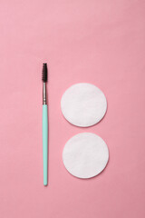 Eyelash brush and cotton pads on a pink background. Beauty concept. Makeup products