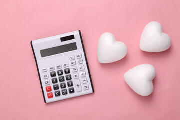 Calculator and hearts on a pink background. Romantic, love concept, valentine's day
