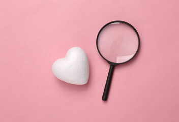 Magnifying glass and hearts on a pink background. Romantic, love concept, valentine's day