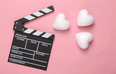 Movie clapper board with hearts on pink background. Romantic, love concept, valentine's day