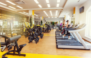 Blurred image of a modern gym with people exercising. Sports background. Gym interior - obrazy, fototapety, plakaty