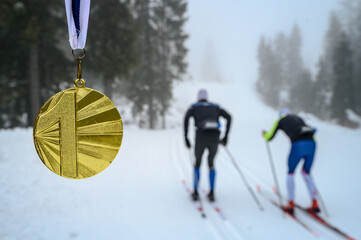 Gold medal, sport trophy, white winter nature in background. Original Wallpaper for winter game in...