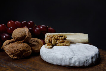 A circle of camembert cheese lies on a wooden board.