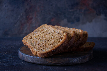 bread with sprouted grain on a wooden board, dark photo