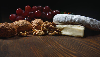 A circle of camembert cheese lies on a wooden board.