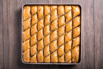 baklava whit pistachio in tray on the wooden table